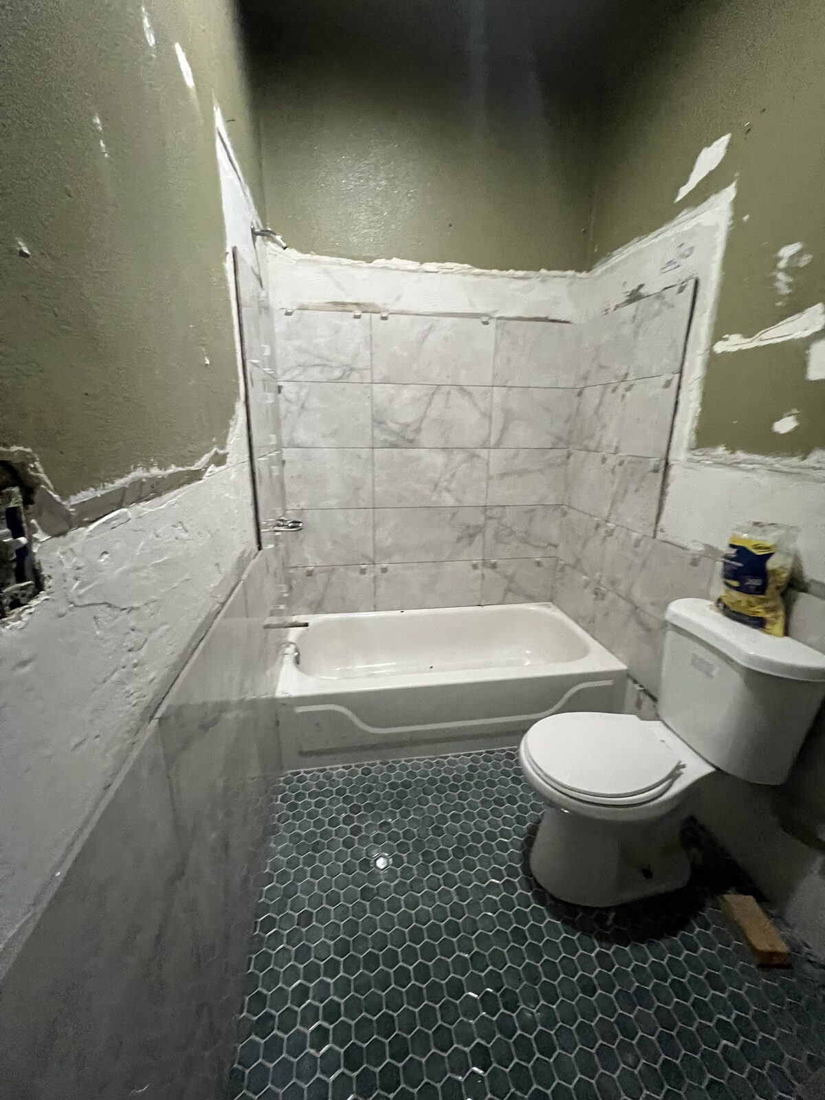 Unit A bathroom during renovation, tile in progress