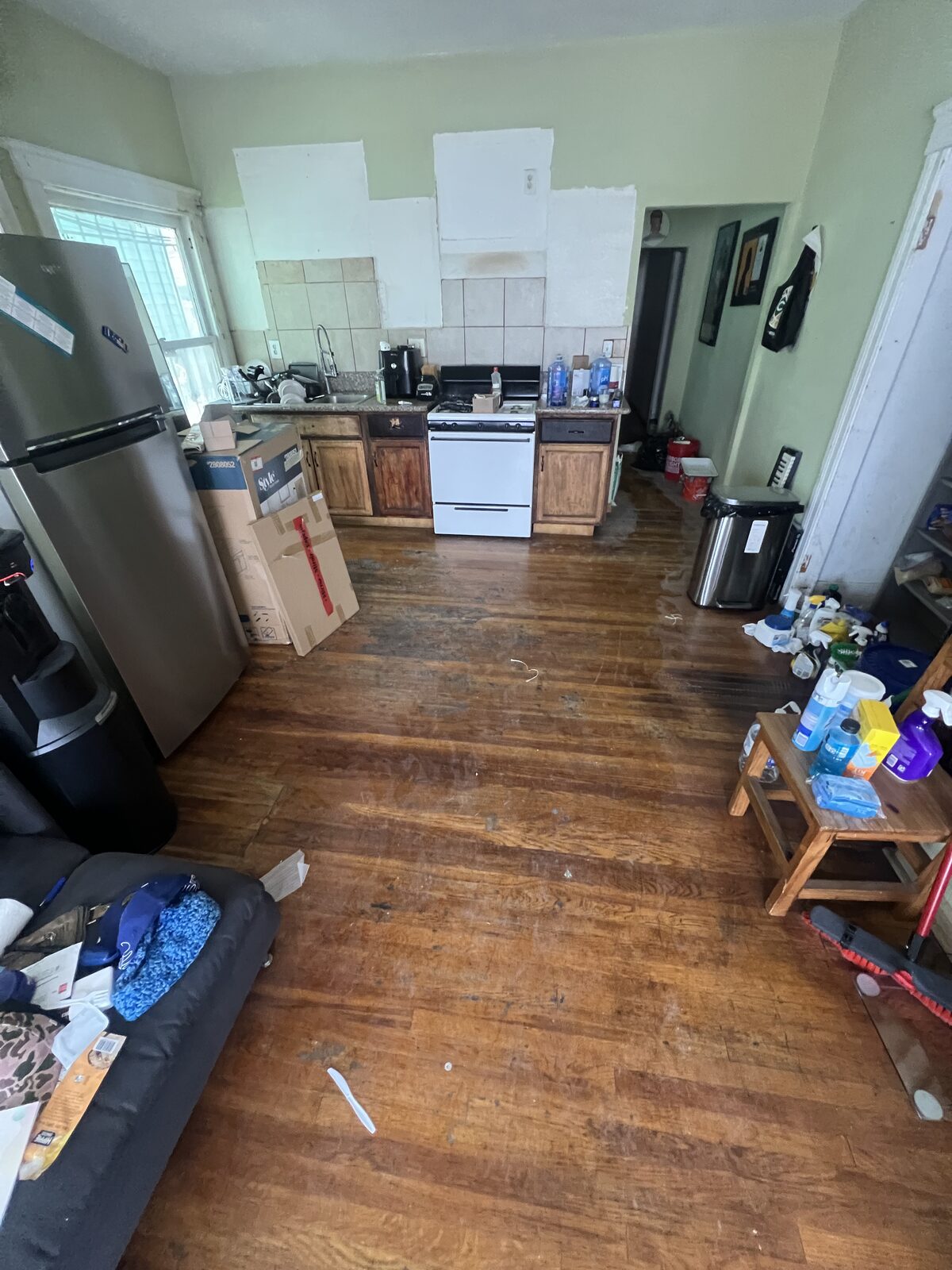 Unit A kitchen mid-renovation with patched walls and original cabinets
